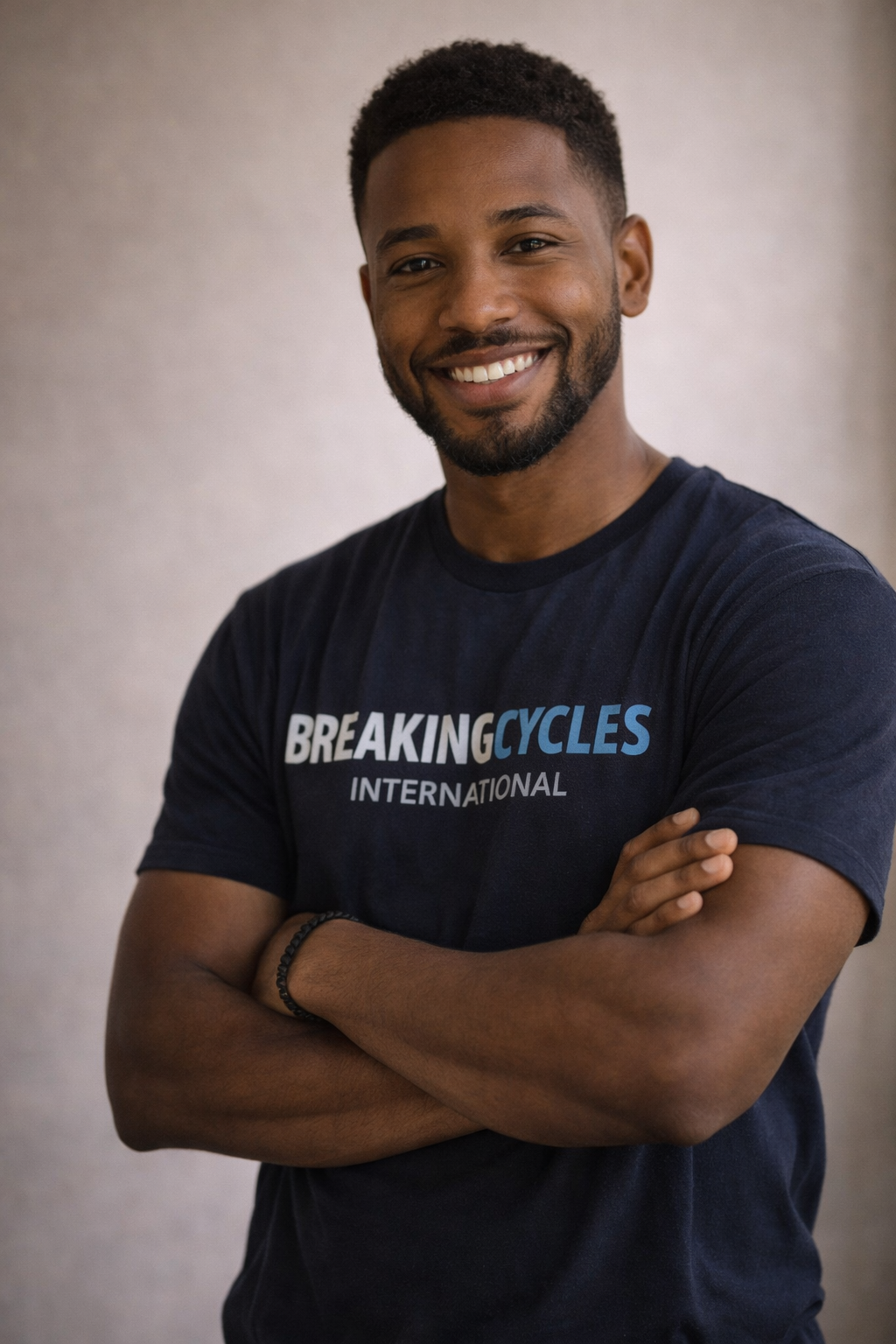 African American Youth mentor wearing a Breaking Cycles International tee shirt standing professionally.